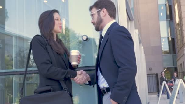 Dois empresários apertando as mãos fora de um prédio de escritórios moderno em câmera lenta — Vídeo de Stock