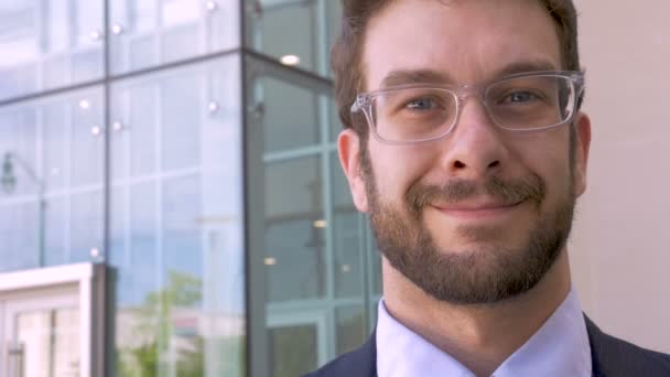 Gut gekleideter Mann Portrait lächelt vor Glas Bürogebäude — Stockvideo