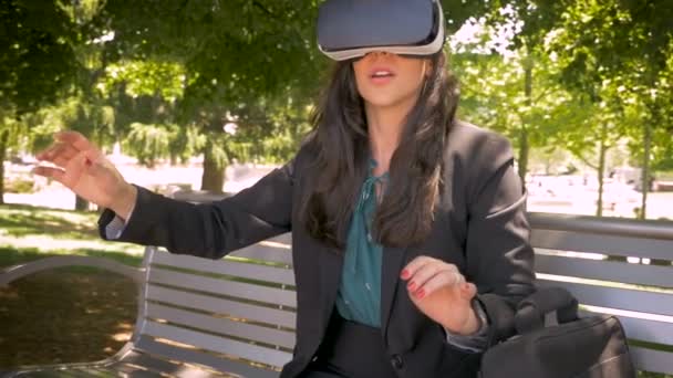 Женщина-офисный работник испытывает виртуальную реальность с VR гарнитурой снаружи — стоковое видео