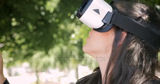 Mulher bonita vestindo fone de ouvido VR e encantada pela realidade virtual — Vídeo de Stock