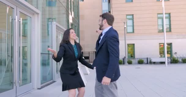 Deux partenaires commerciaux haut cinq et danser à l'extérieur de l'immeuble de bureaux dans 4k — Video