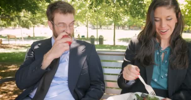 Doi tineri tineri directori de afaceri atrăgători care mănâncă alimente sănătoase în afară — Videoclip de stoc