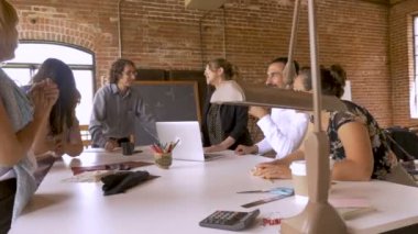 Grup reklam bir toplantısında gülüyor ve başarılı bir iş kutluyor
