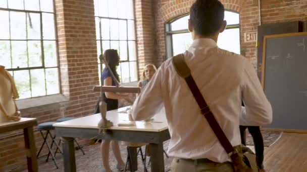 Câmera segue hispânico homem chegando para trabalhar com colegas de trabalho do sexo feminino na inicialização — Vídeo de Stock