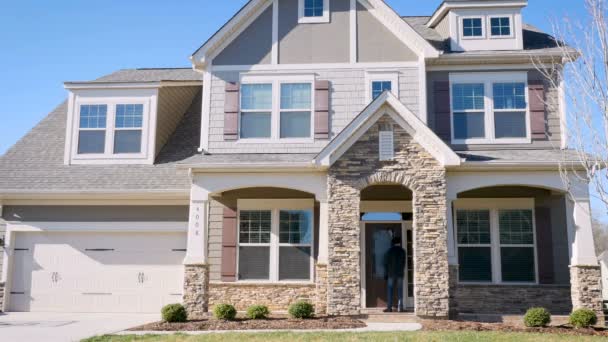 Homem deixa sua casa tranca a porta da frente e sai de sua casa suburbana — Vídeo de Stock