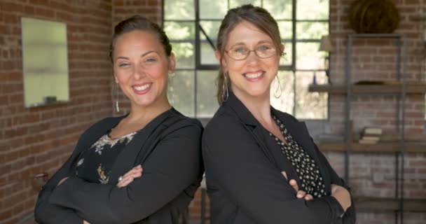 Дві потужні привабливі бізнес-леді, що стоять спиною до спини посміхаючись — стокове відео