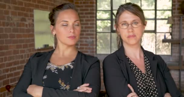 Dos mujeres serias y asertivas se miran y luego la cámara — Vídeos de Stock
