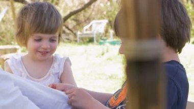 İki sevimli küçük çocuklar gülümseyerek mutlu bir yetişkin dışarıda oynamak