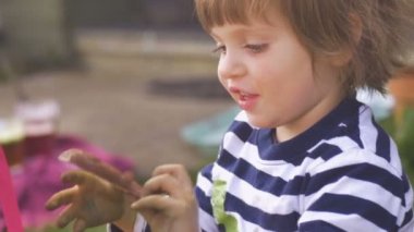 Ağır çekimde çikolata dışarıda bir ısırık alarak mutlu küçük kız