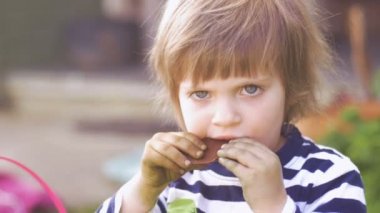 Ağır çekimde çikolata dışında biraz şeker bir ısırık alarak küçük kız