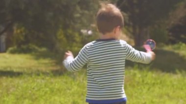 Sevimli küçük çocuk ağır çekimde kabarcıklar yapma çevrelerin iplik