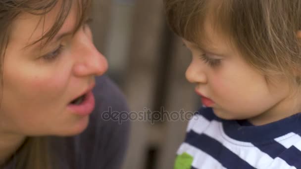 Mother talking to her young daughter mentoring and teaching her something — Stock Video