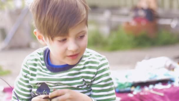 Adorable niño feliz comiendo chocolate afuera en cámara lenta — Vídeos de Stock