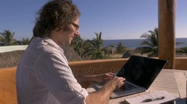 Yakışıklı adam laptop plaja bakan ev ofisinde hâlâ