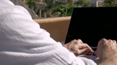 Bilgisayarda plajda çalışan dijital göçebe erkeğin OTS