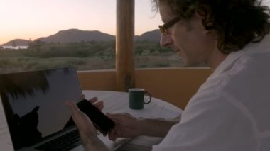 Plaj kullanarak boyunca uzak ofis çalışma adam akıllı telefon ve çağrı yapma