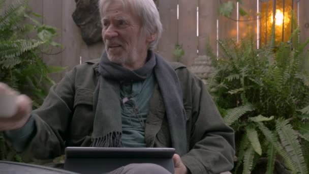 Homem aposentado feliz rindo e bebendo sake usando seu tablet digital — Vídeo de Stock