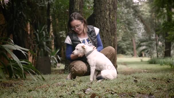 Felice donna cane proprietario baciare il suo animale domestico fuori in natura — Video Stock