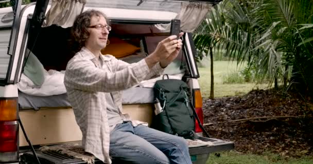 Мужчина 30 лет делает панорамное фото и селфи со своим смартфоном — стоковое видео