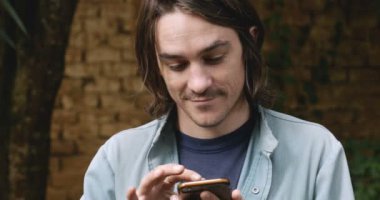 Mutlu bin yıllık adam akıllı telefon teknolojisi arar ve gülümsüyor kamera ile
