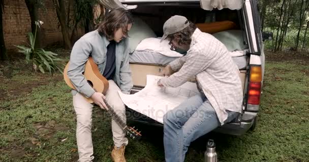 Momento íntimo de dois amigos homens olhando para um mapa juntos dolly wide — Vídeo de Stock