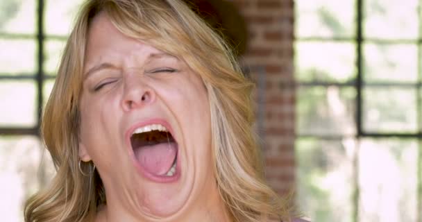 Чрезвычайно уставшая переутомленная женщина зевает и выражает усталость — стоковое видео