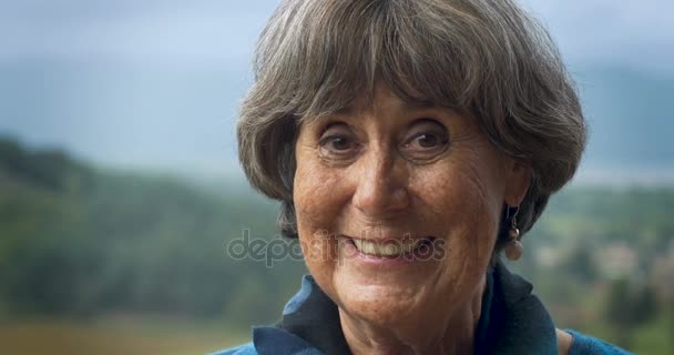 Красивая пожилая женщина в возрасте 60 лет улыбается в камеру — стоковое видео