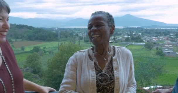 Афроамериканка трется лицом, рассказывая историю своим друзьям за 60. — стоковое видео