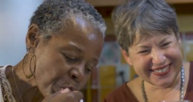 İki kadın arkadaş yeme, içme ve birlikte bir partide gülüyor 60