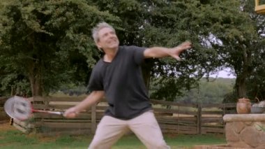 Badminton oynamaya ve kameraya bakarak onun 60s mutlu komuta sizde gülümseyen