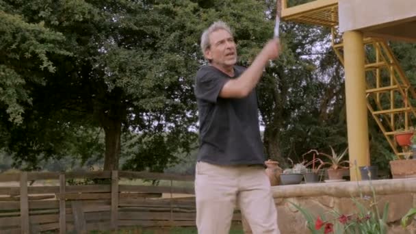 Homme âgé actif dans les années 60 jouant au badminton au ralenti — Video