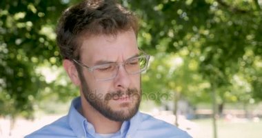 Çok kızgın adam gözlüklerini çeker ve öfkeli kameraya bakıyor