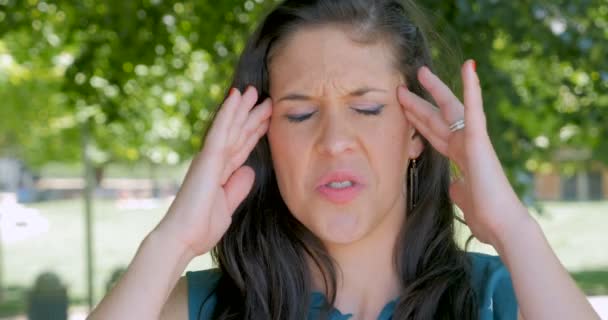 Mutsuz kızgın genç kadın onun tapınak bir baş ağrısı ile masaj — Stok video