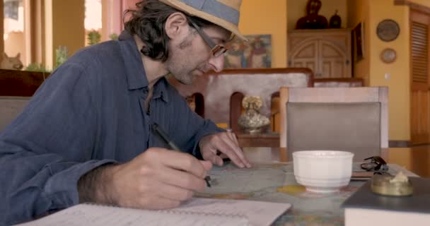 Attractive man doing research using a map and notebook — Stock Video