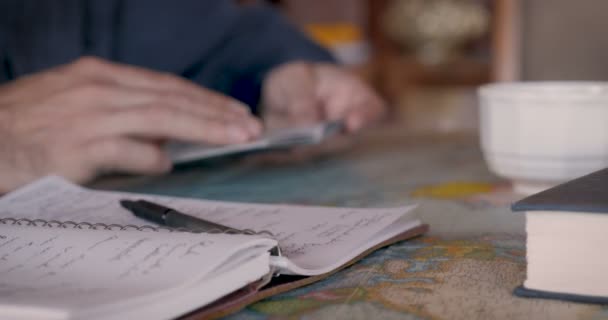 Крупним планом чоловік, який перевертається через свій паспорт, дивлячись на карту світу — стокове відео