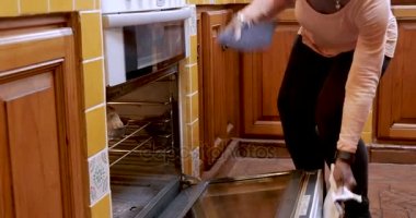Afro-Amerikan Olgun kadın fırın açar ve taze somun ekmek kaldırır