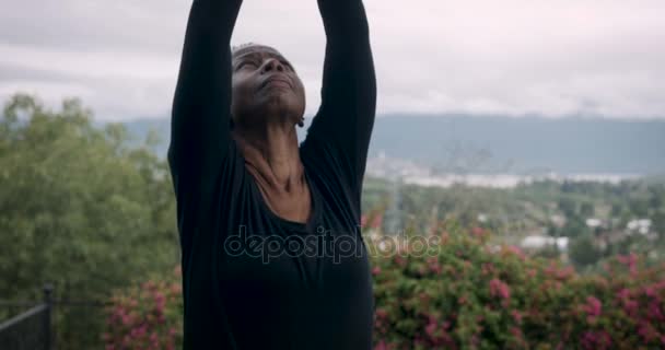 Baby boomer actif femme afro-américaine exerçant yoga soleil salutation pose — Video