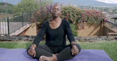Emekli Afrikalı-Amerikalı kadın sessizce dinlenme bir yoga mat meditasyon