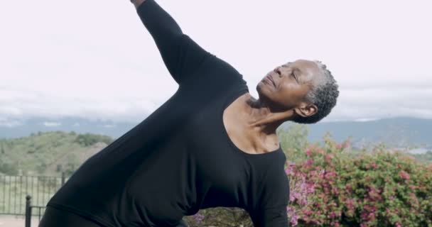 Attraente in forma donna afroamericana negli anni '60 praticando yoga triangolo posa — Video Stock