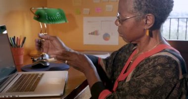 Afrikalı-Amerikalı kadın bir bilgisayarda yazarak bilek eklem ağrıları nedeniyle durur