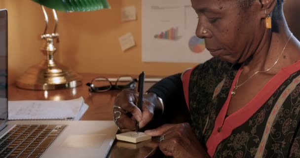 Krásná africká americká zralá žena psaní na žlutou poznámek sticky notes — Stock video