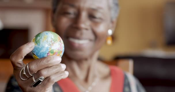 Fröhliche afrikanisch-amerikanische Frau blickt auf Weltkarte Globus und lächelt — Stockvideo