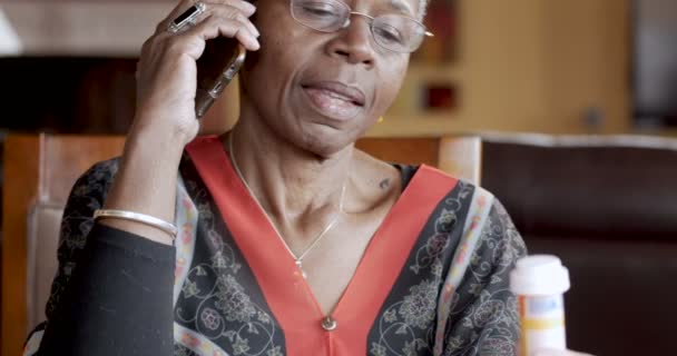 Belle femme âgée noire remplissant sa prescription sur un téléphone intelligent — Video
