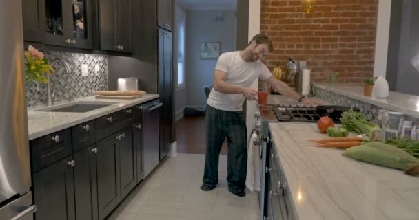 Hombre atractivo terminando su café deja su cocina bailando con teléfono móvil — Vídeo de stock