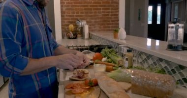 Adam ile dilimlenmiş Şarküteri et ev mutfağında sandviç