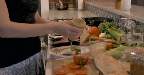 在纸盘子上的三明治上用塑料瓶榨芥末的女人 — 图库视频影像