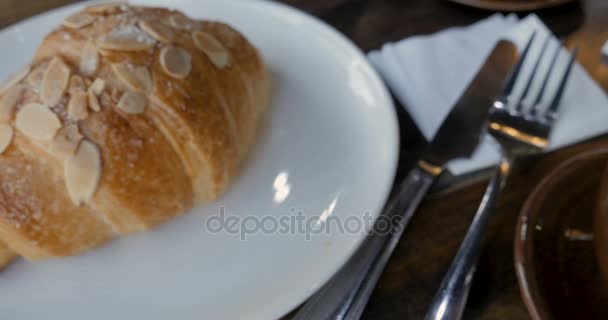 Dolly lento de delicioso café con leche arte y repostería croissant desayuno — Vídeos de Stock