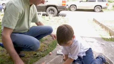 Baba ve oğul yavaş hareket dışında tebeşir ile birlikte oynarken