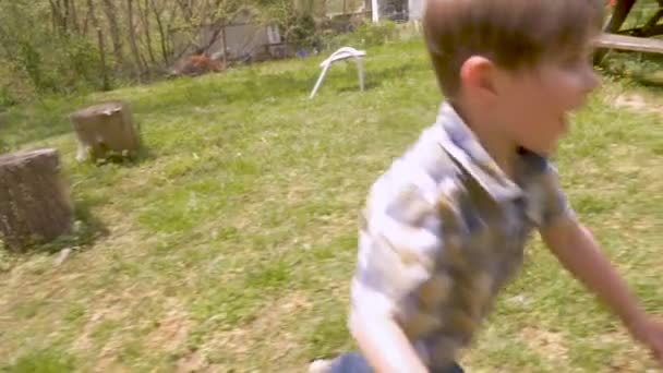 Excited boy running to get an easter egg before another boy in slow motion