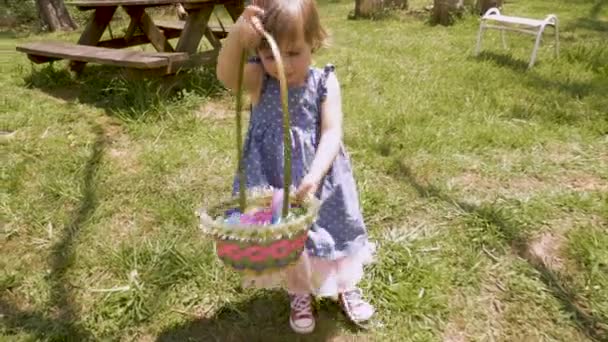 Adorable niña de 2 a 3 años en vestido de primavera sosteniendo una cesta de Pascua — Vídeo de stock